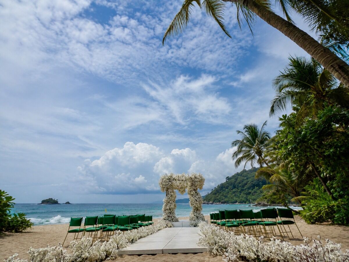 Beach wedding ceremony setup with green chairs and a white floral arch overlooking the ocean in Costa Rica