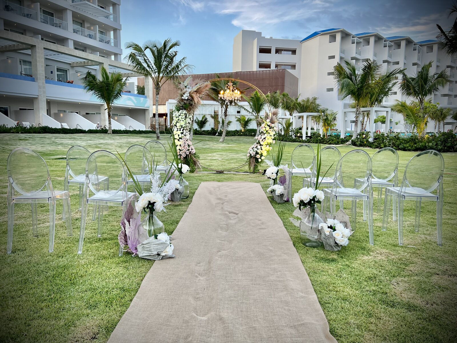 An outdoor lawn wedding ceremony at dusk with the officiant standing beside the couple, the kind of moment that only lands smoothly if the script and rehearsal are locked in weeks ahead