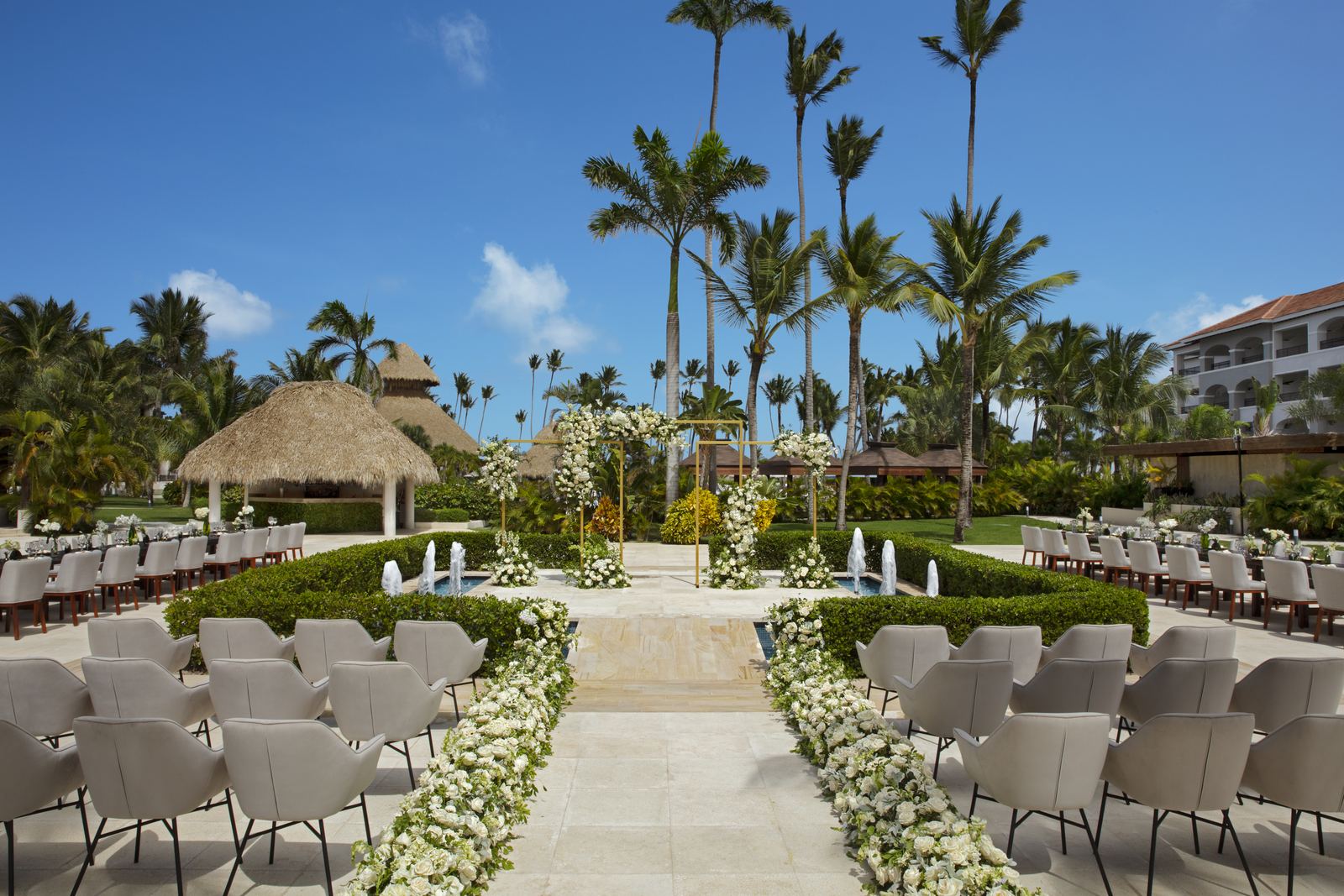 Resort ceremony terrace with fountains and floral-lined aisle