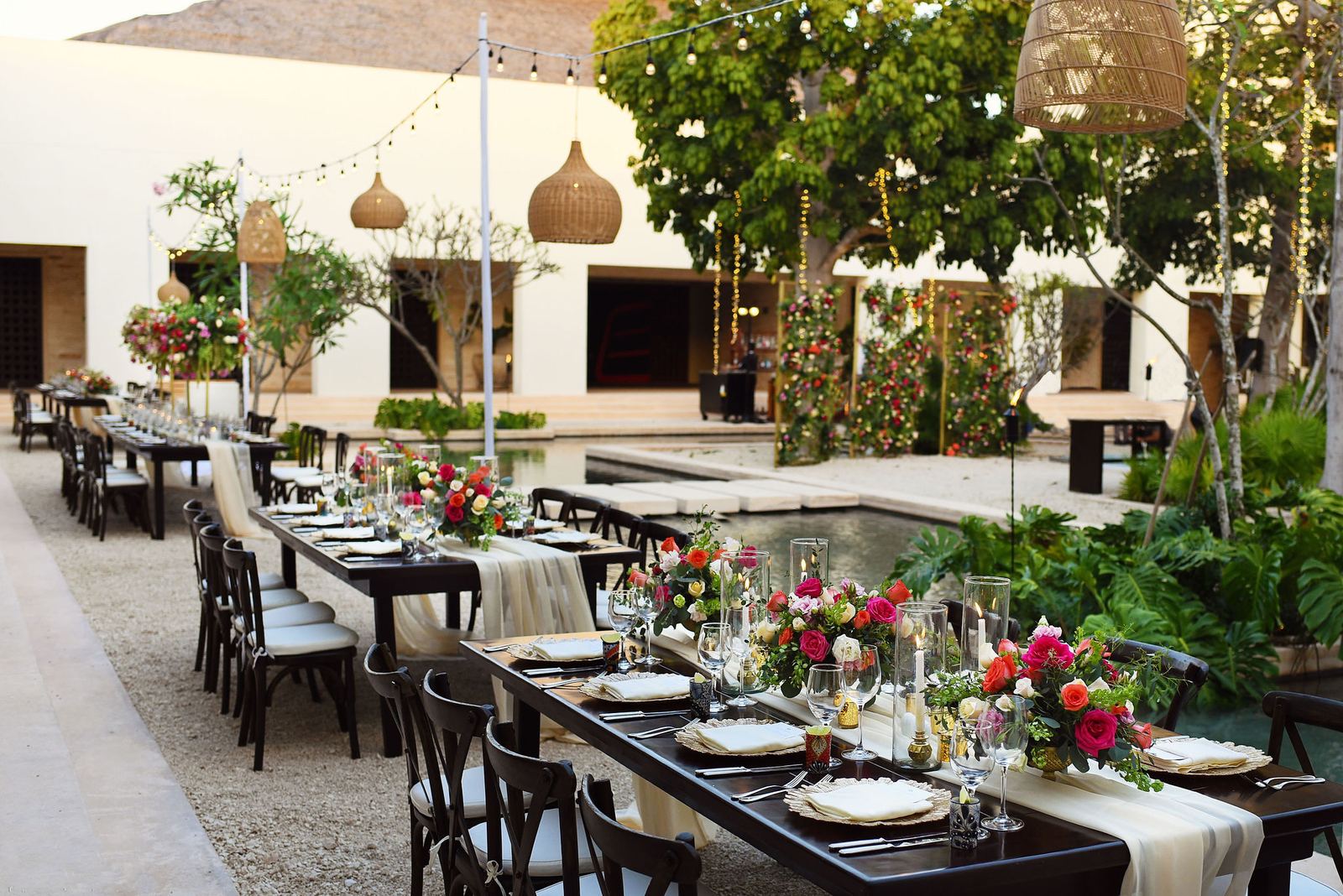 Wedding group reception in a resort plaza with long tables and floral installations