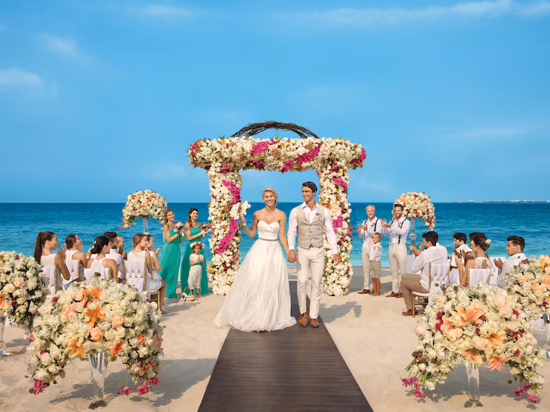 An open beach wedding venue at Dreams Playa Mujeres with rows of chairs facing the ocean, ready for a large ceremony