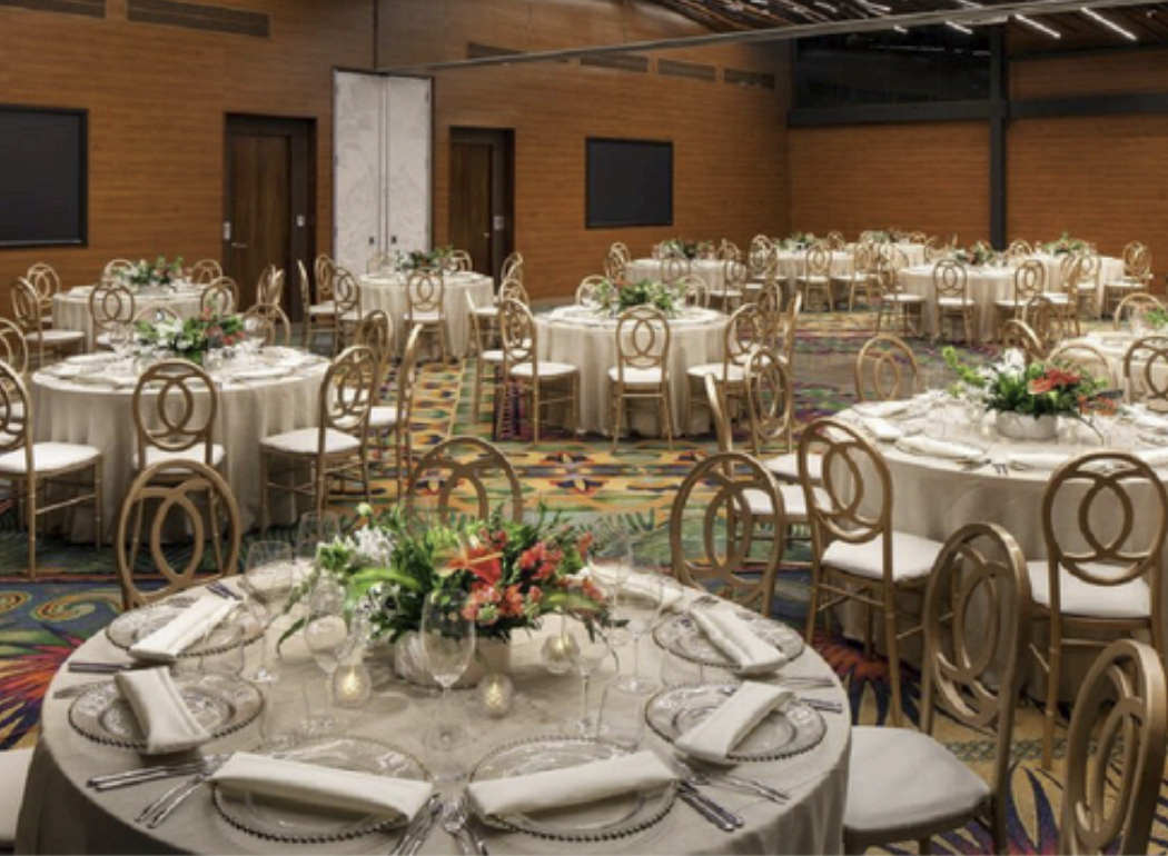 Indoor ballroom reception with round tables and gold chairs at the Great Room, W Costa Rica Reserva Conchal