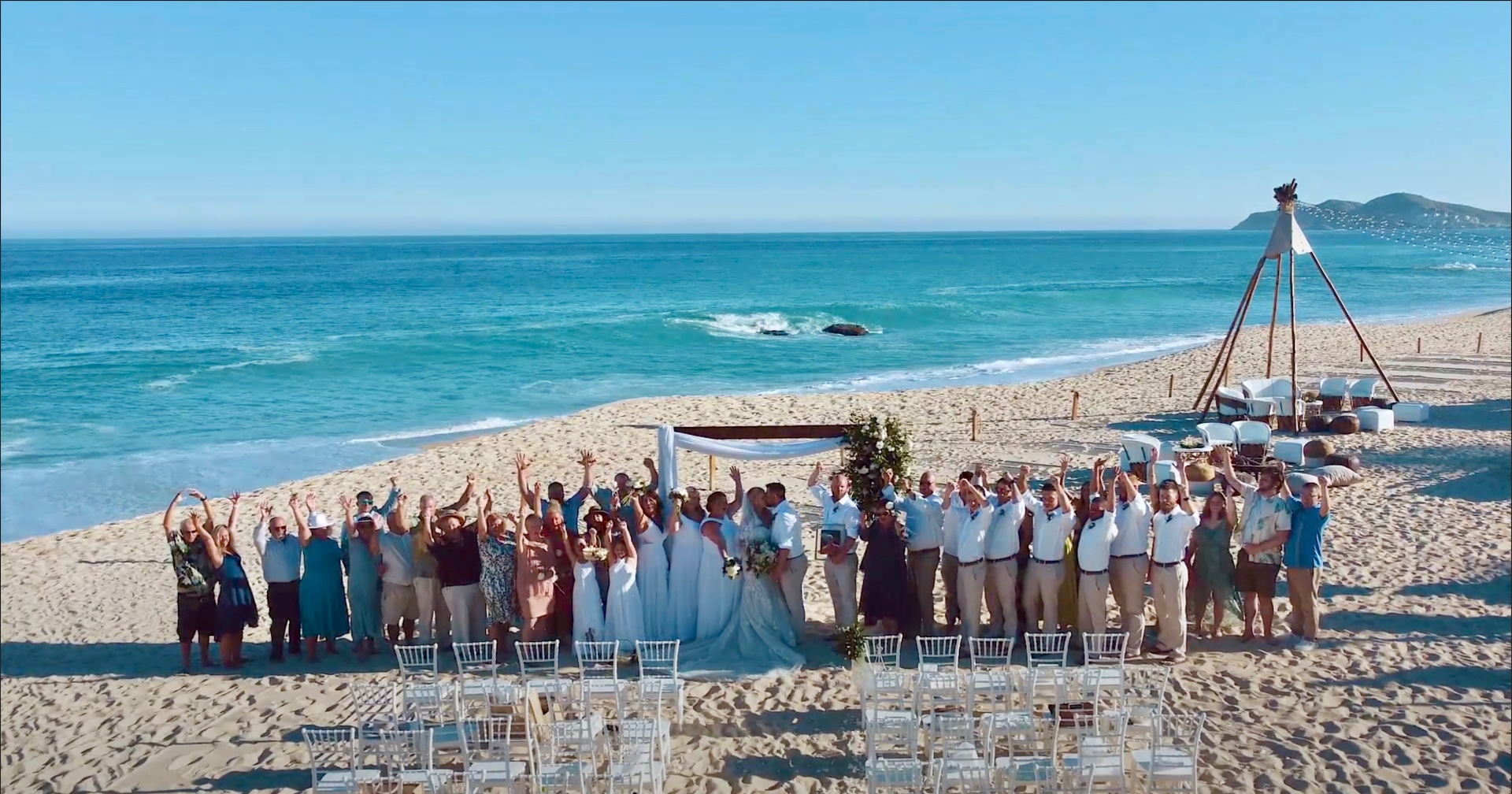 Destination wedding guests standing during an outdoor ceremony