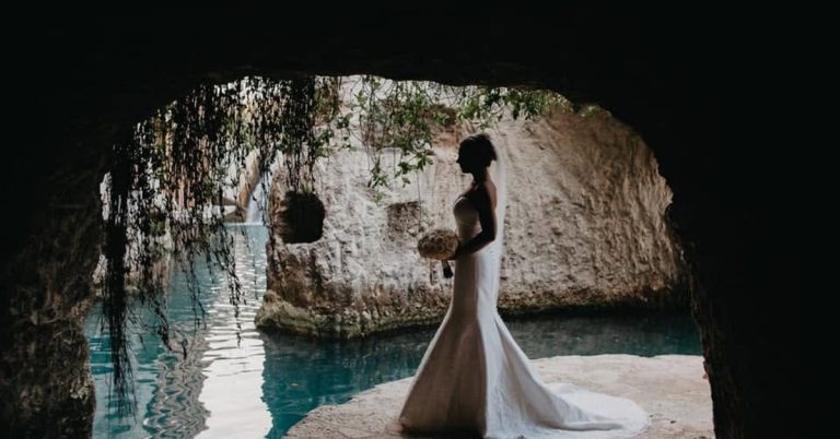 Bride portrait inside a natural cave with turquoise cenote water at Hotel Xcaret, Mexico