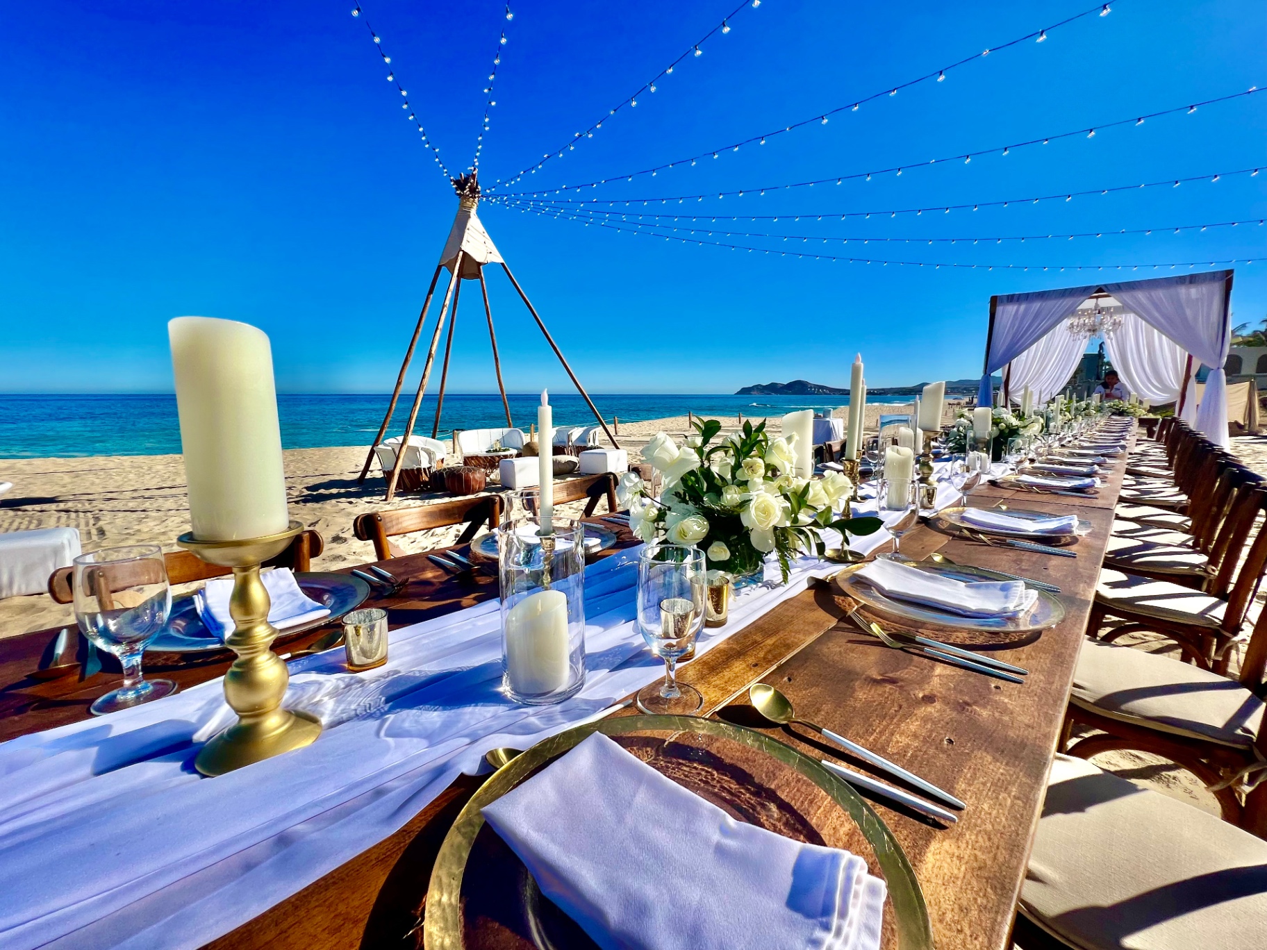 Elegant plaza reception setup at a destination wedding with string lights and formal dining tables