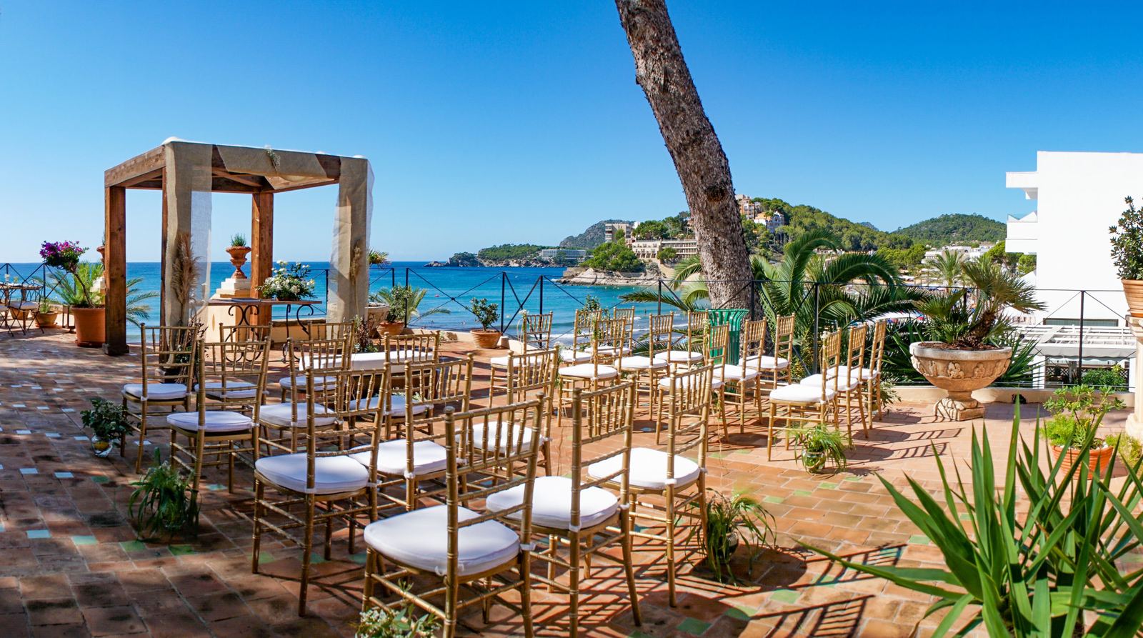 Outdoor destination wedding reception with string lights and garden seating