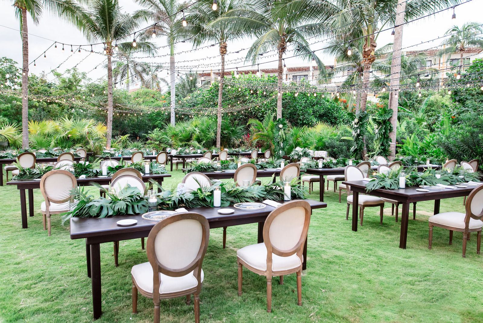 Upgraded reception tablescape with colorful florals and string lights at a destination wedding
