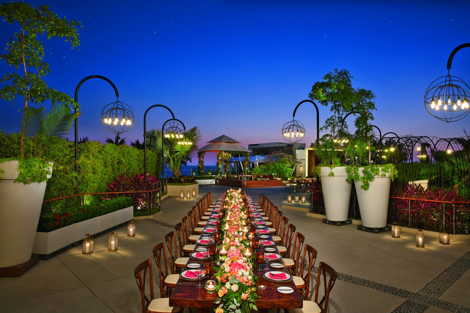Evening reception terrace with string lights overlooking the ocean at a resort