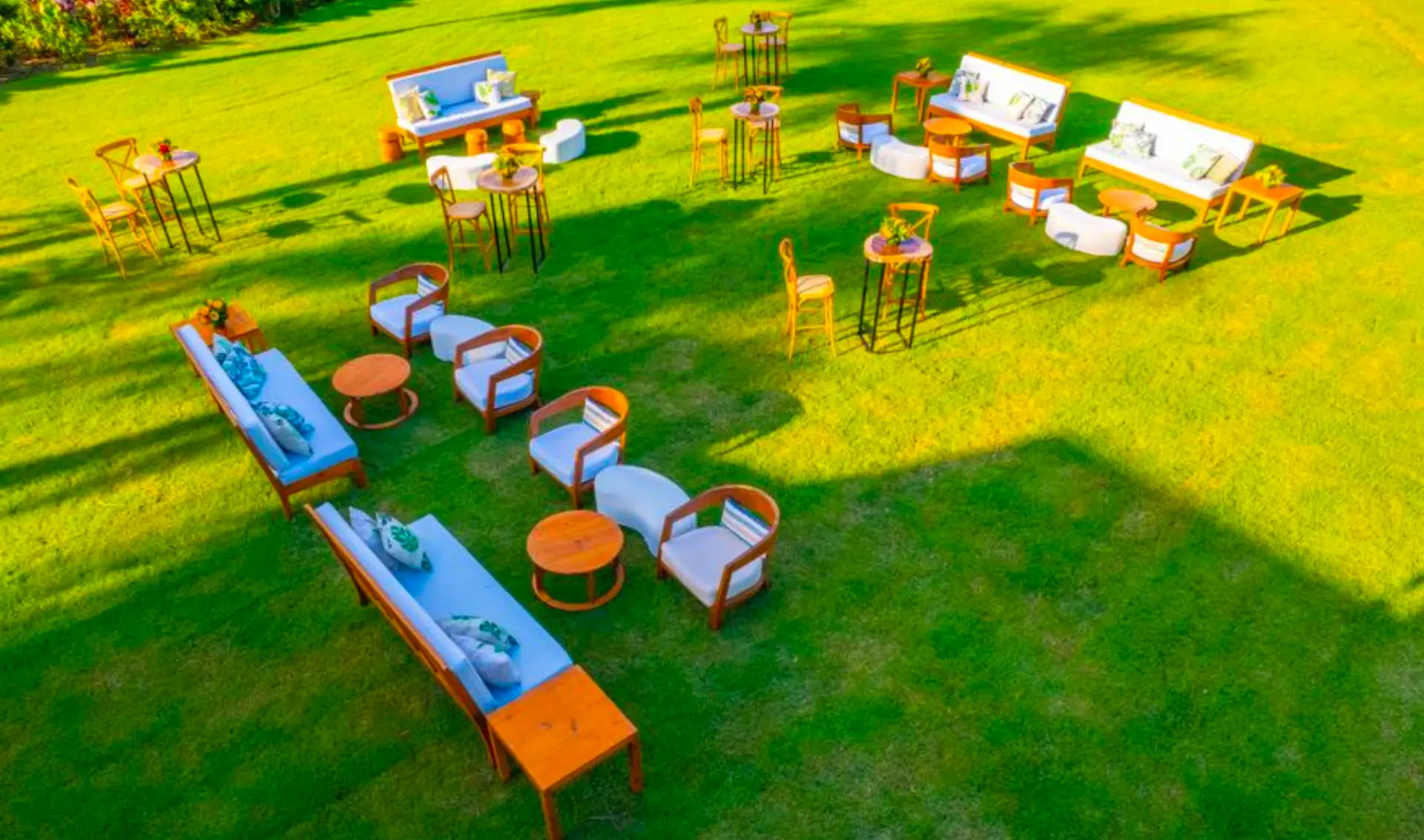 Outdoor lounge seating with light blue sofas and white benches on the Caribe garden lawn for an adults-only wedding reception