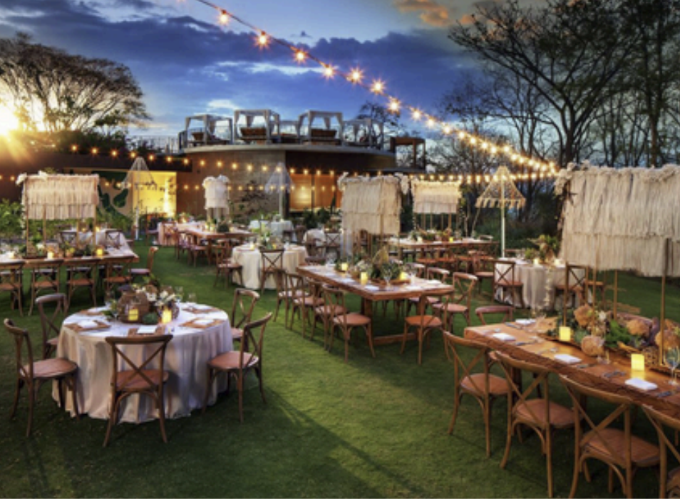 Outdoor lawn reception at dusk with string lights and cabana-style tables at W Costa Rica Reserva Conchal