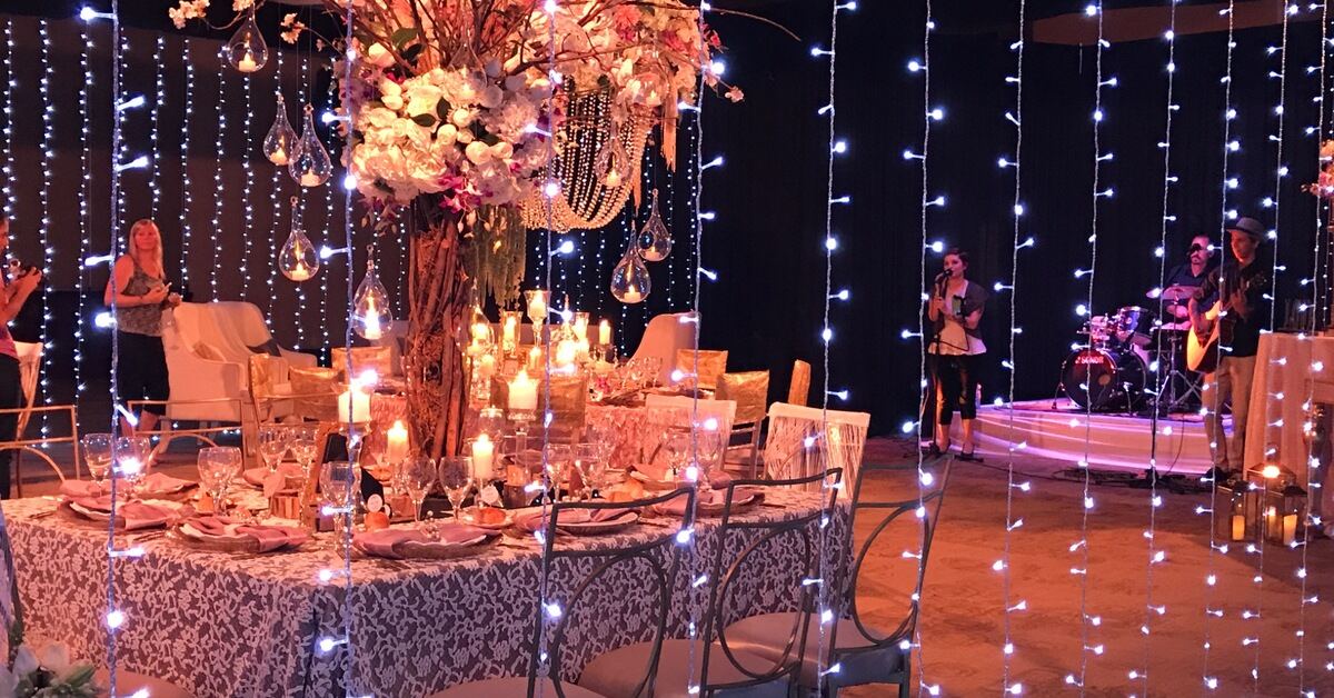 Candlelit Costa Rica wedding reception with floral centerpieces, hanging lights, and live music