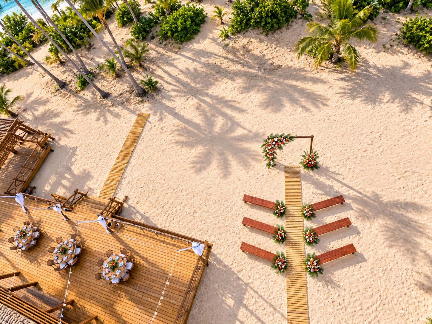 Aerial view of Secrets Beach Club wedding setup with beach ceremony benches and deck reception tables in the sand