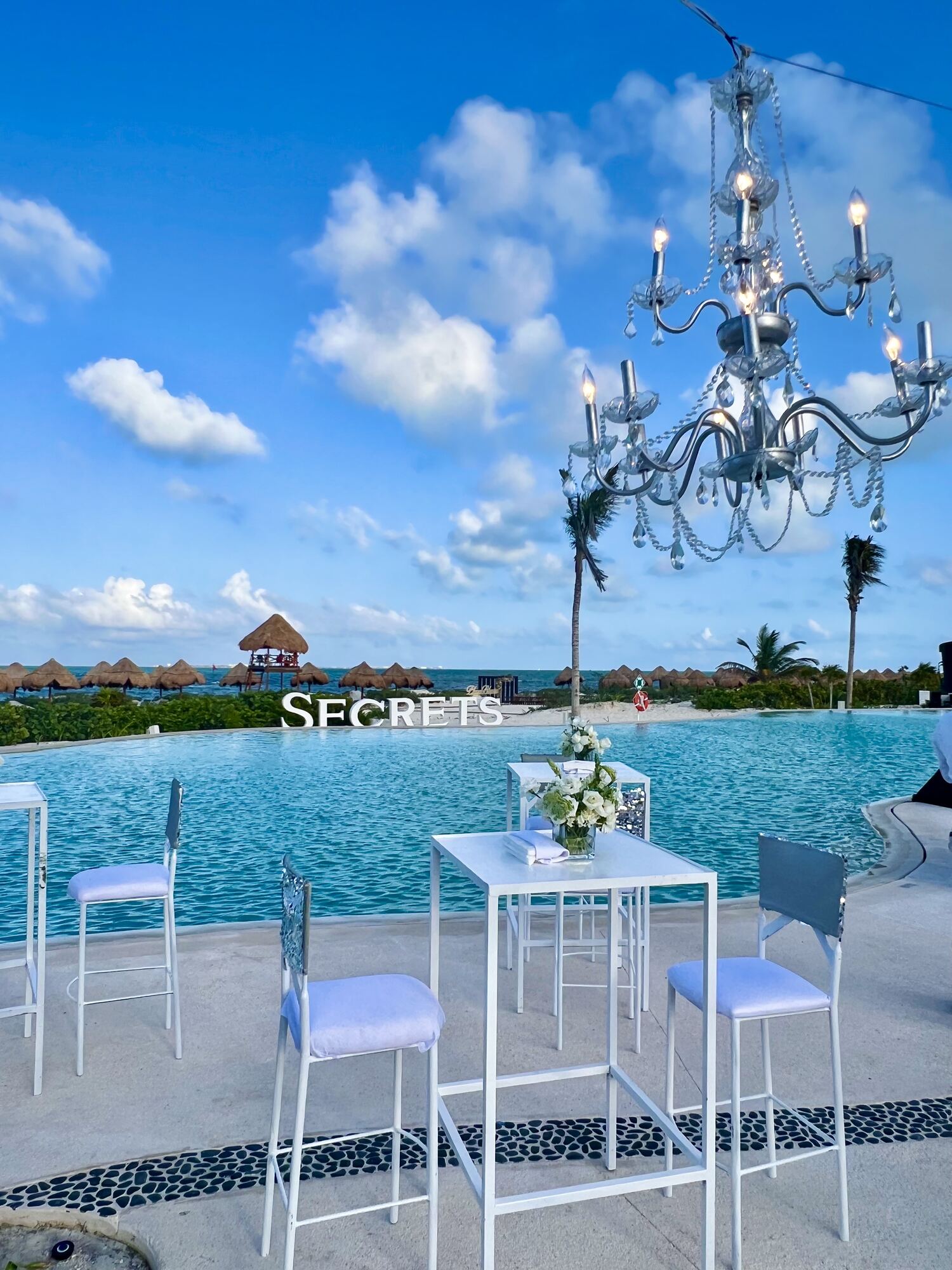 Destination wedding guests enjoying the resort pool — the more relaxed setting where the timeshare approach usually happens.