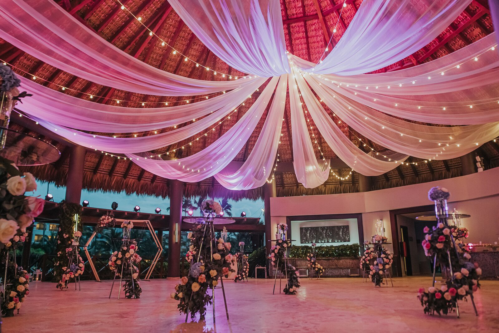 A draped-ceiling reception lit with string lights, the kind of intimate destination setting where speeches carry easily and deserve to stay short
