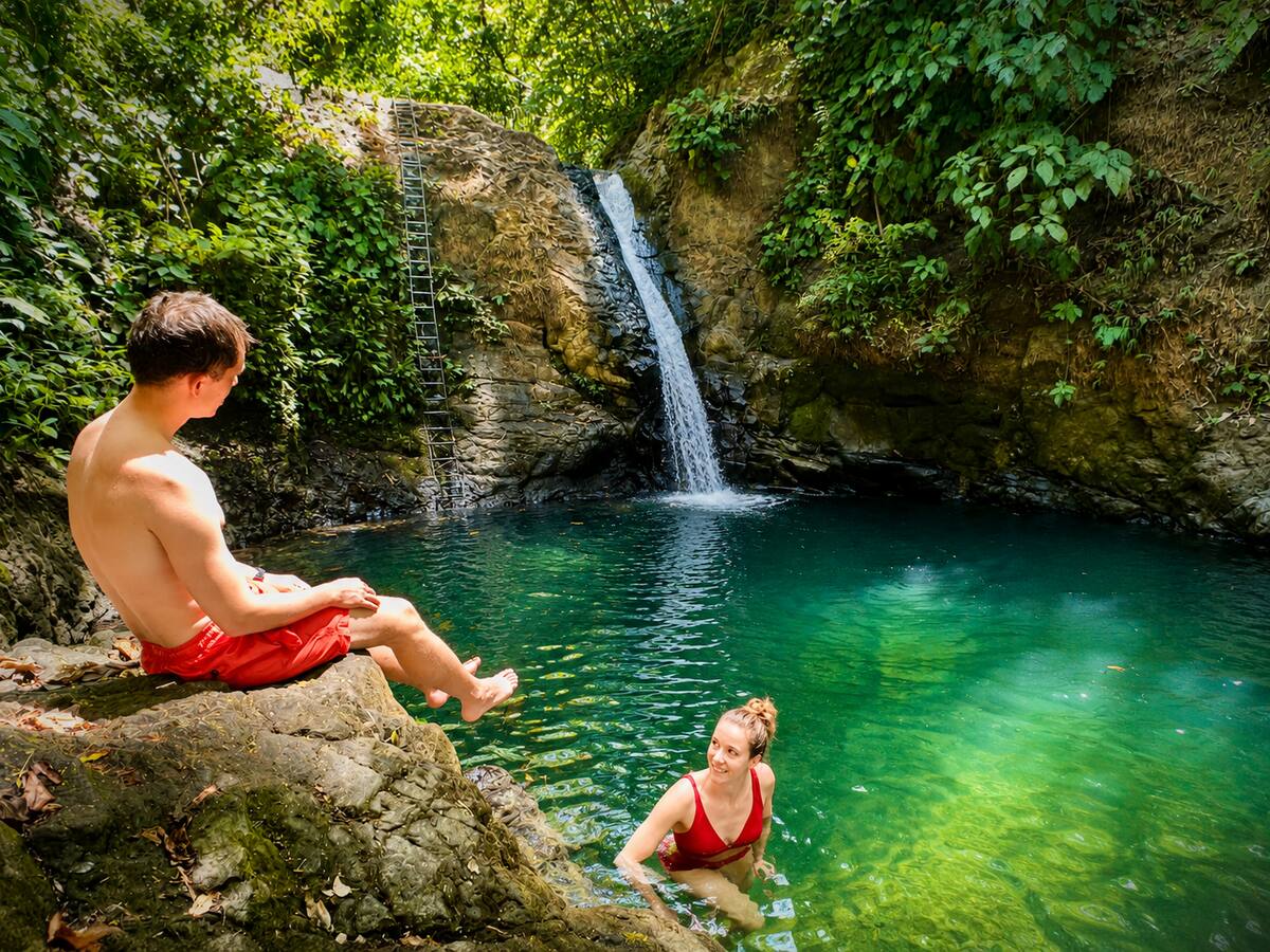 Couple swimming and relaxing at a jungle waterfall pool near Uvita, Costa Rica