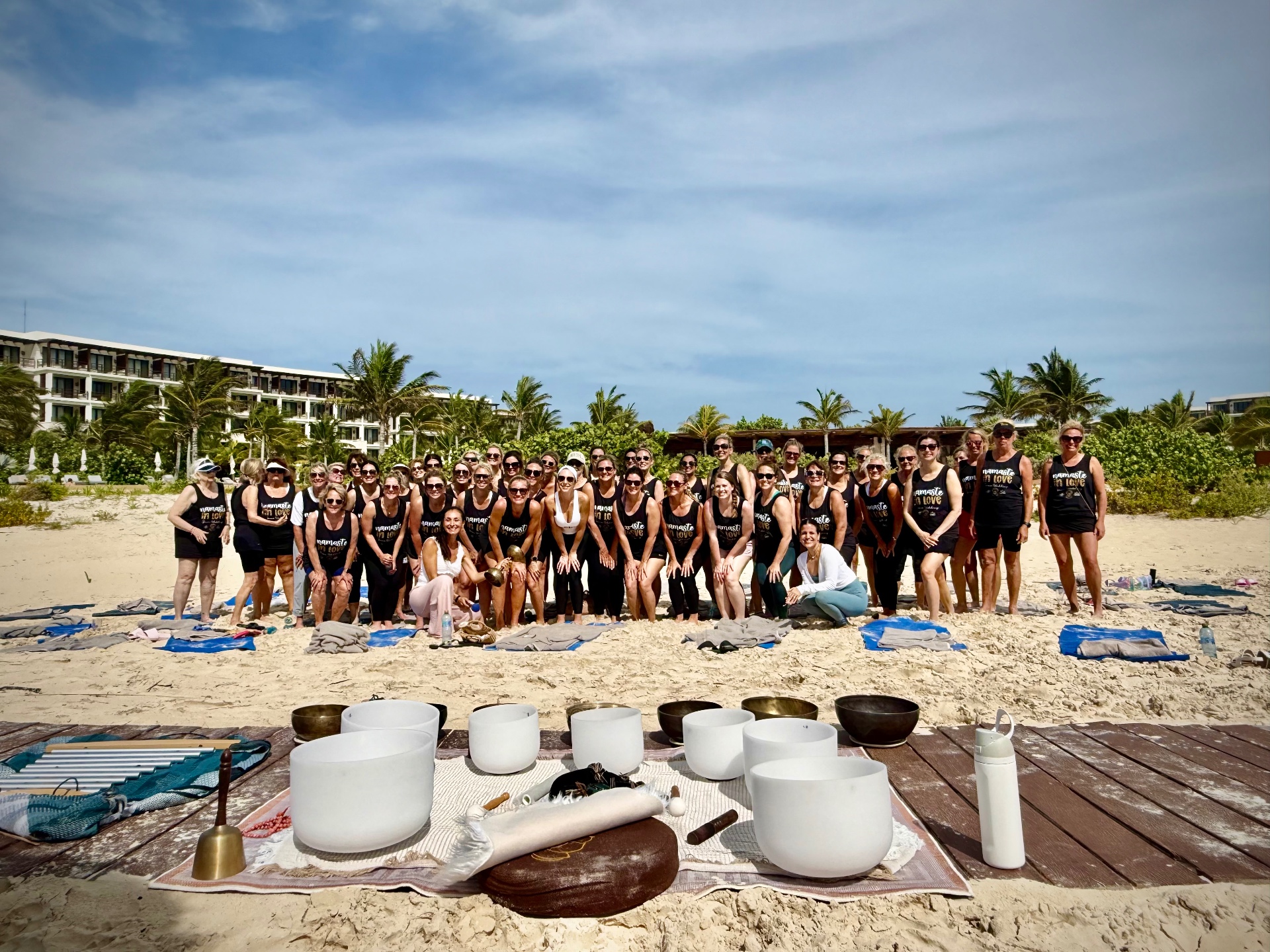 Guests doing a group beach yoga session the morning after the wedding