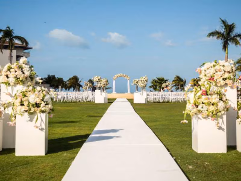A platform-style central garden wedding venue at Dreams Playa Mujeres, showing a mid-size ceremony setup surrounded by tropical landscaping