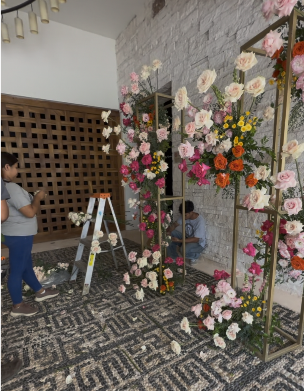 Florist building a gold floral arch on-site for an all-inclusive wedding package