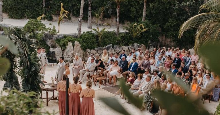 Wedding ceremony guests seated at an outdoor ceremony surrounded by jungle and stone at Hotel Xcaret